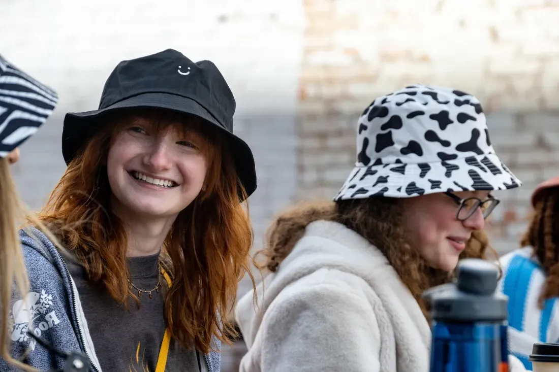 两个学生戴着帽子，一起微笑.